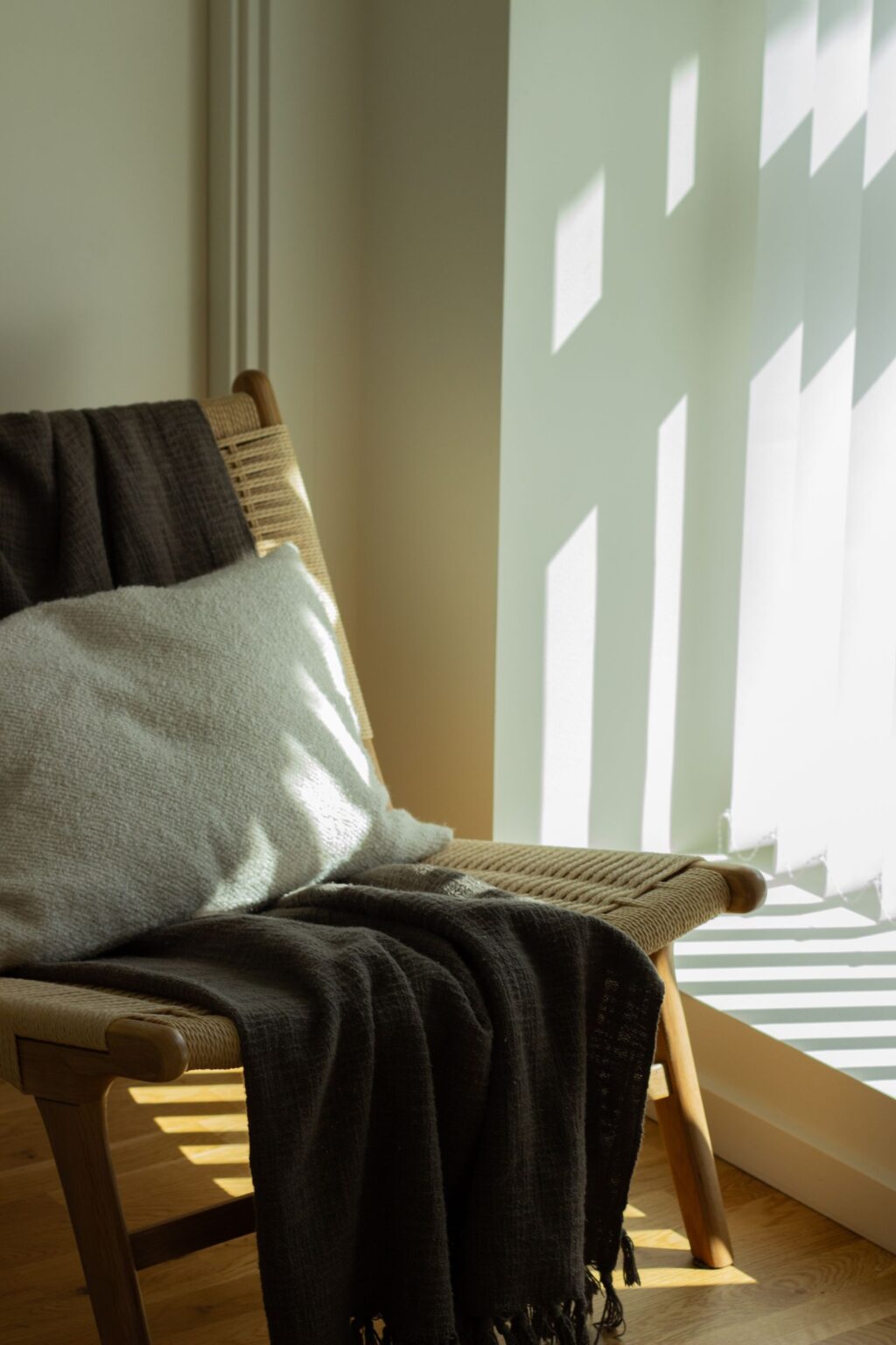 Sage throw blanket draped over a chair in sunlight