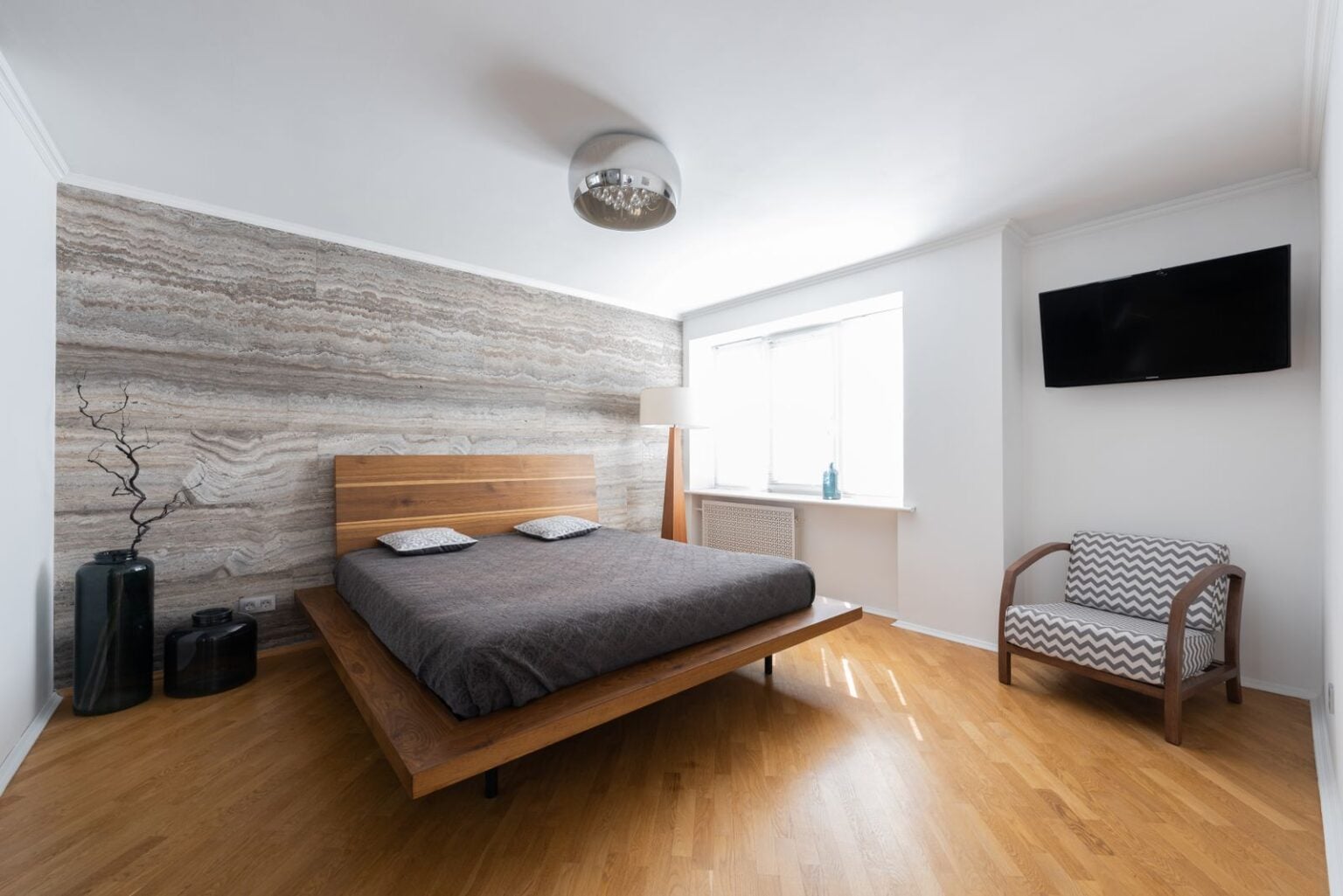 Low oak platform bed in a calm bedroom