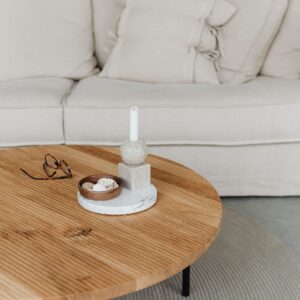 Round oak coffee table in front of a linen sofa