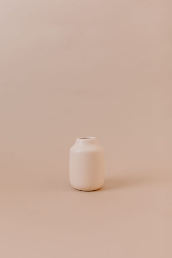 Small white vase on a beige surface