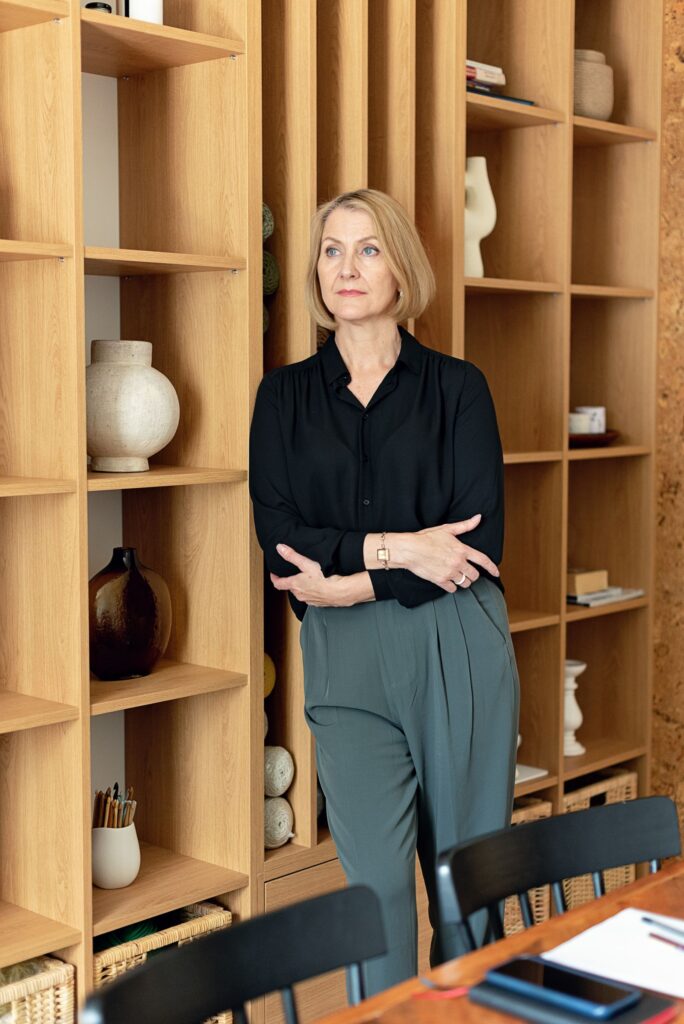 Portrait of a designer standing beside oak shelving