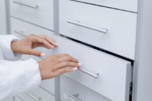 Hand opening a white filing drawer