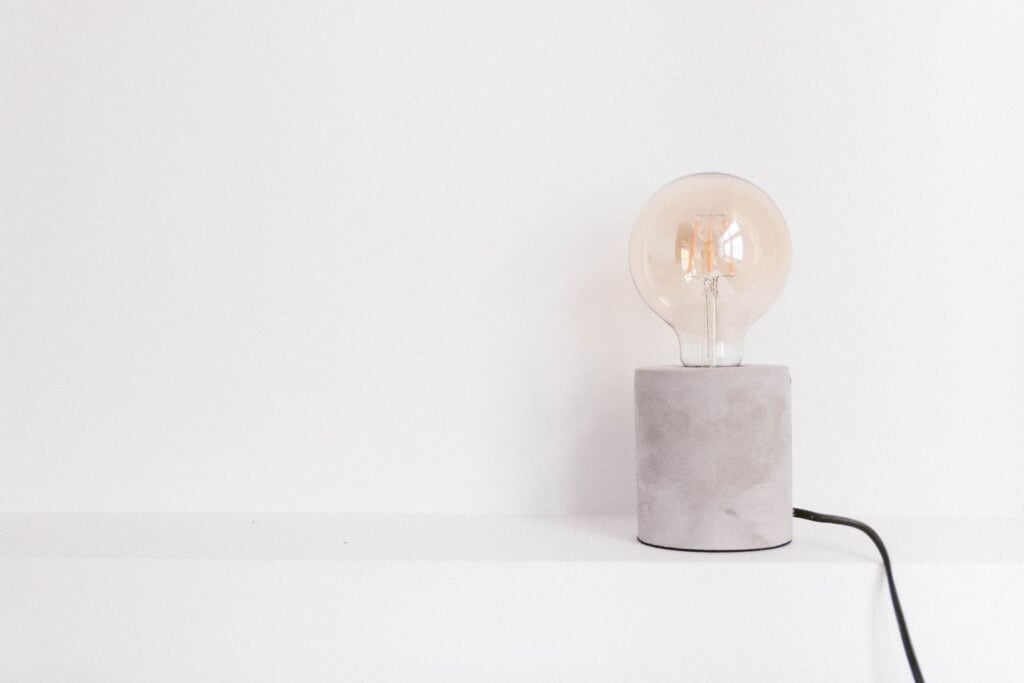 Stone Bulb Lamp with a globe bulb on a concrete base