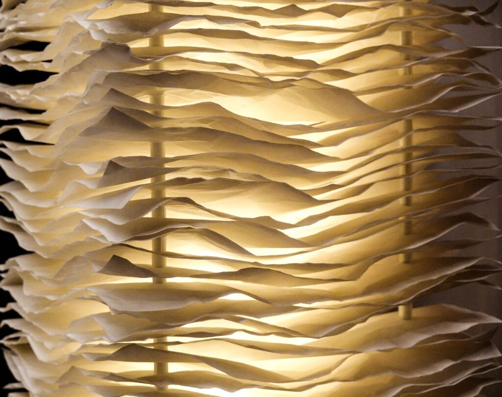 Layers of pleated paper glowing from behind