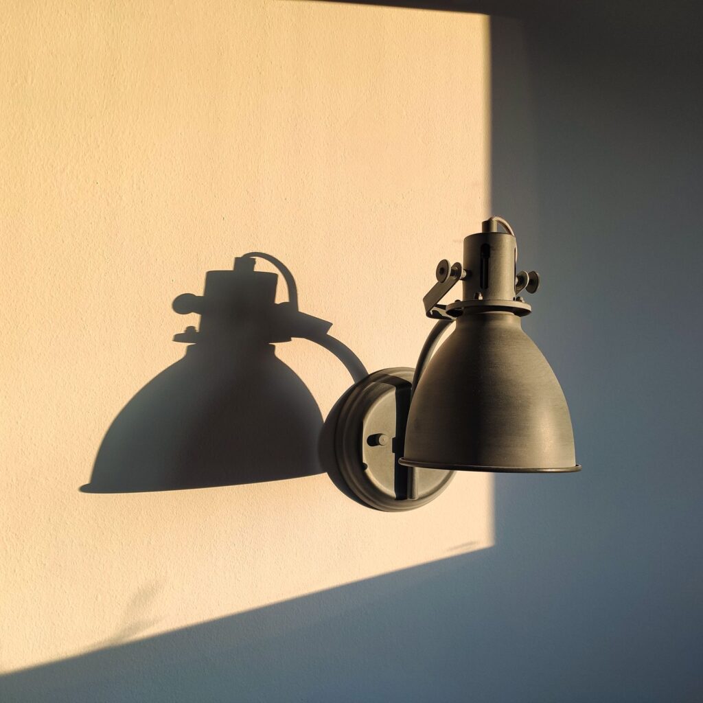 Two Arc Wall Lamps in blackened steel on a sunlit wall