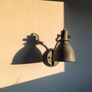 Two Arc Wall Lamps in blackened steel on a sunlit wall