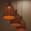 Three Kurv rattan pendants glowing