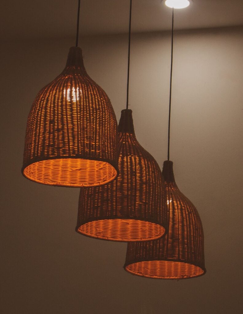 Three Kurv rattan pendants glowing