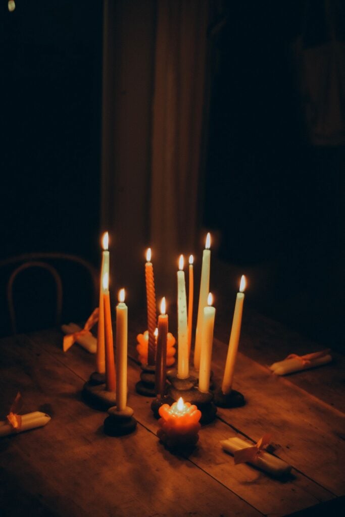 Candles burning on a wooden table at night