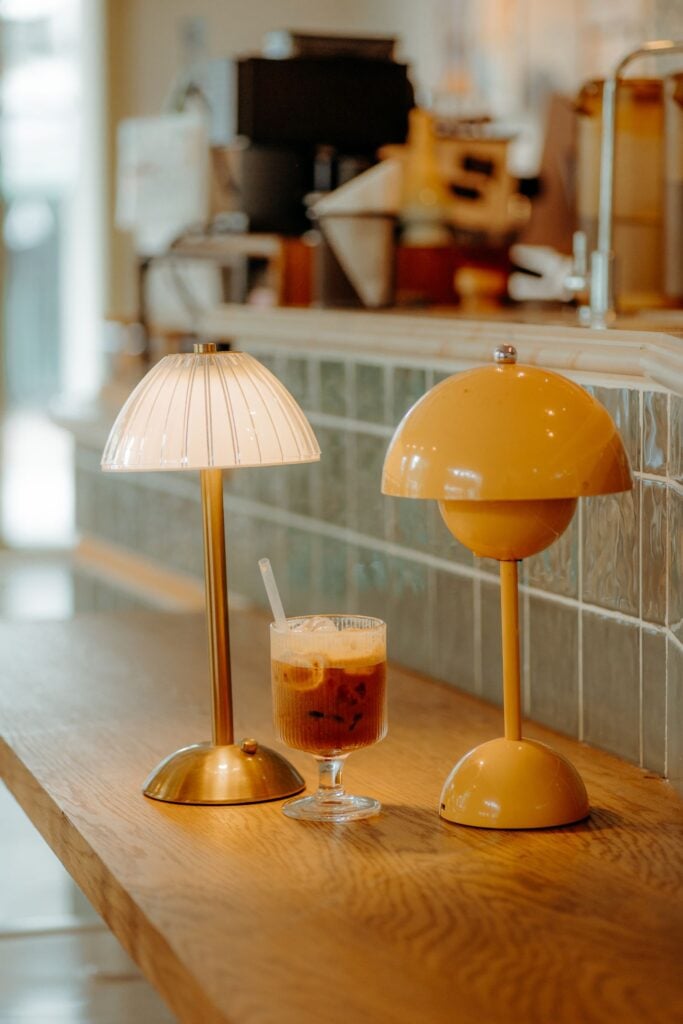 Petal Cordless Lamp with a pleated glass shade on a café counter