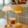 Bloom Table Lamps in saffron and bone on a café counter