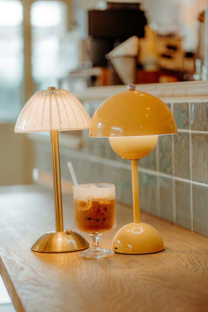 Bloom Table Lamps in saffron and bone on a café counter