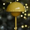 Bloom Table Lamp in saffron with its opal globe lit