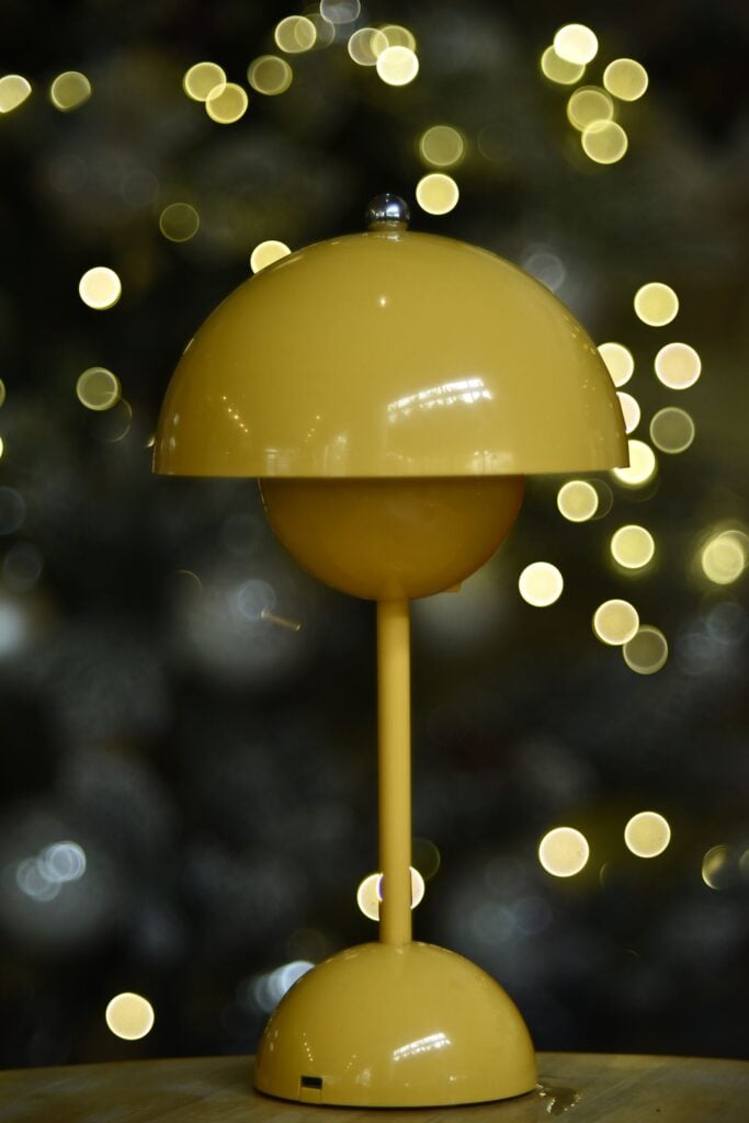 Bloom Table Lamp in saffron with its opal globe lit