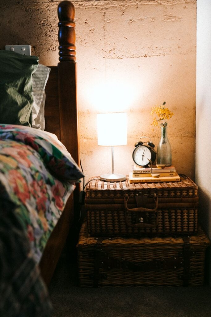 A small bedside lamp beside a vase of flowers