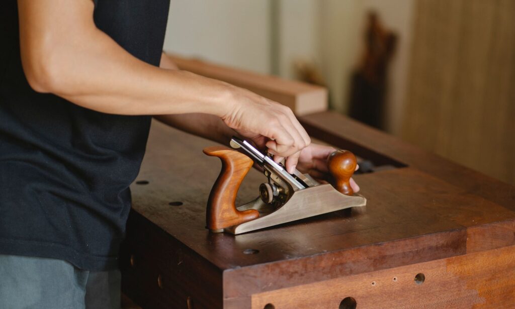 A hand plane resting on a length of oak