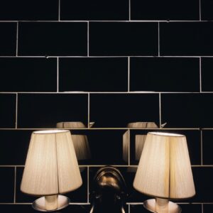 A pair of Pleat Wall Lamps on dark tile
