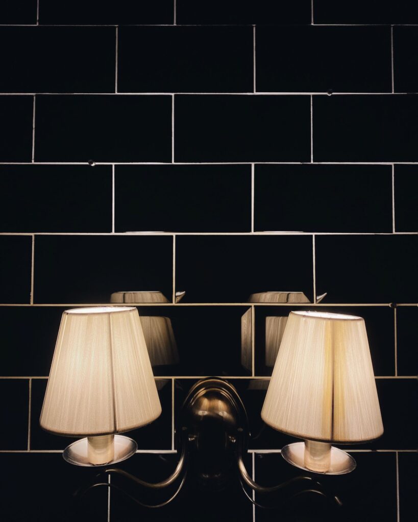 A pair of Pleat Wall Lamps on dark tile