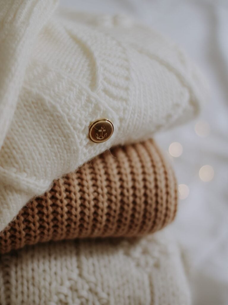 A cream cardigan folded over a caramel rib knit