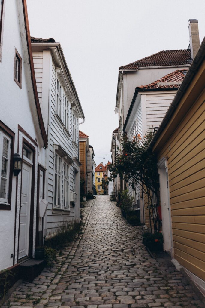 A narrow cobbled lane between white timber houses in Bergen