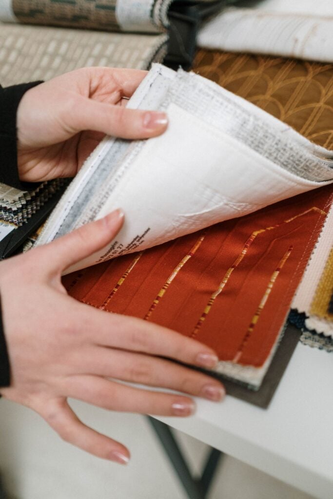Hands leafing through a book of fabric samples